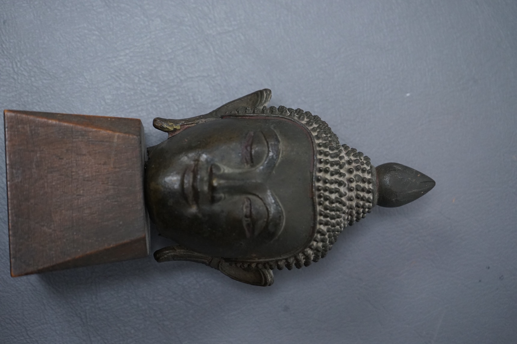 A 17th/18th century Thai, Ayuthia style, bronze head on wooden stand - 14cm high including stand.